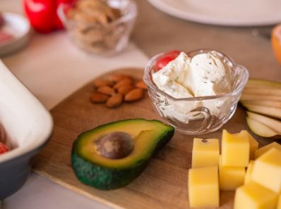 A vibrant platter of cheese, fruits, and vegetables on a wooden board, perfect for gatherings.