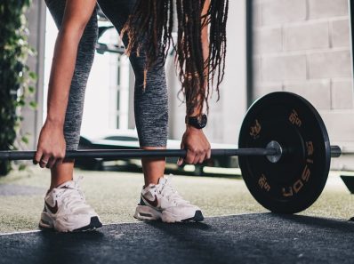 a woman lifting a barbell in a gym