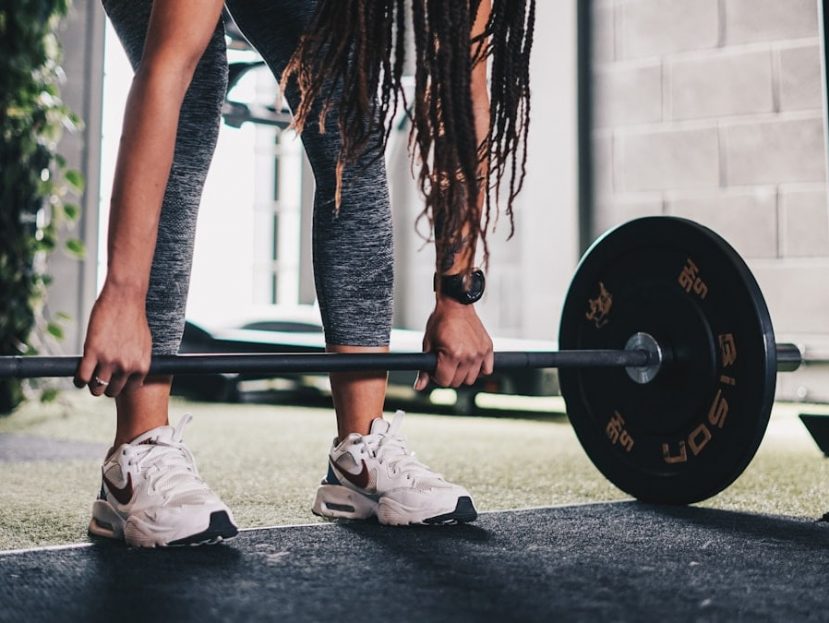a woman lifting a barbell in a gym